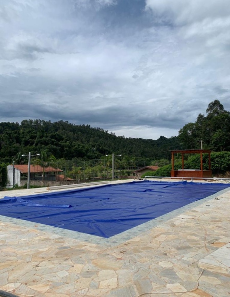 Piscina com capa térmica azul instalada em Águas de Lindóia